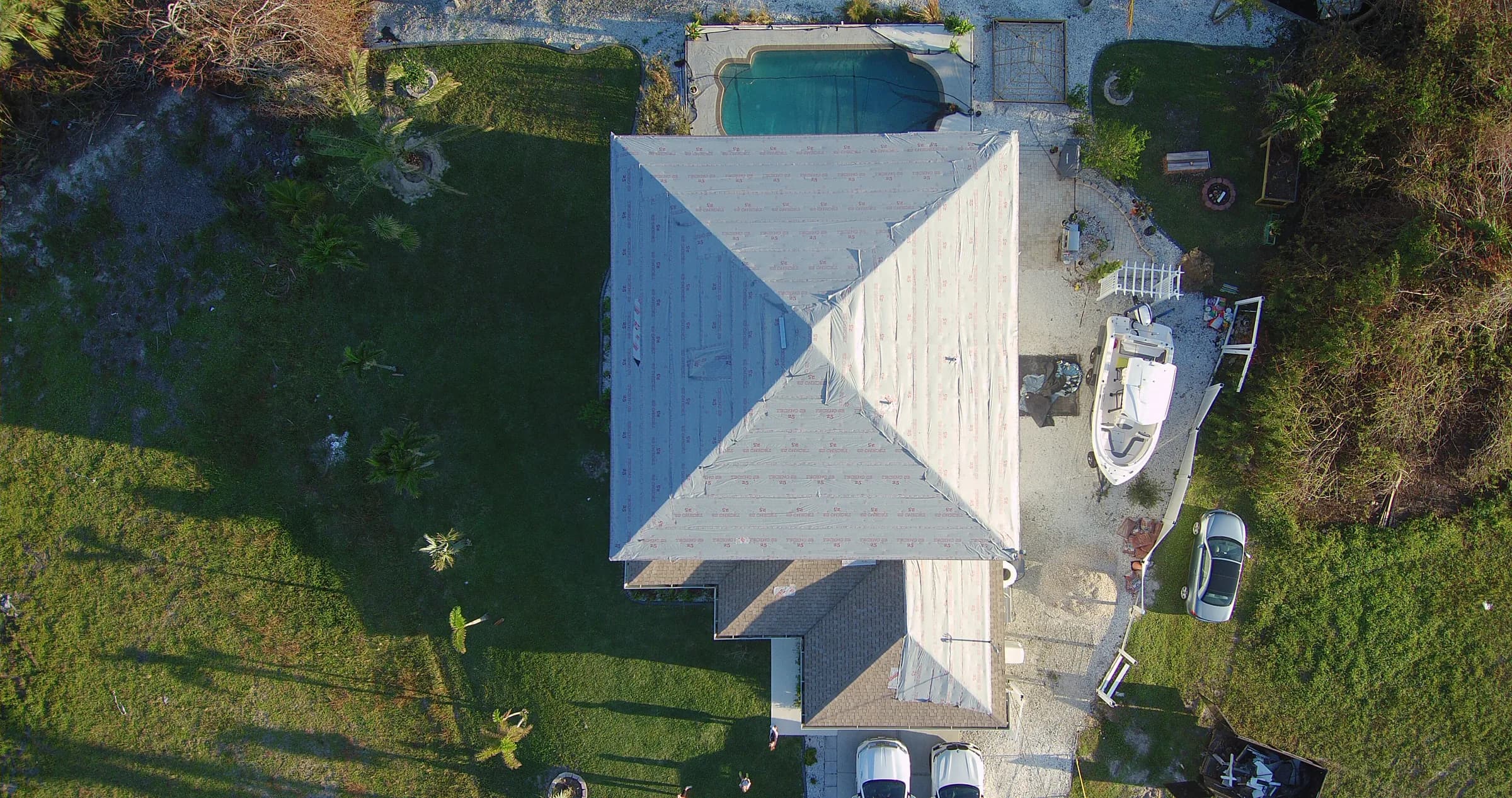 Straight-down aerial view documenting exposed roof underlayment during tile roof work