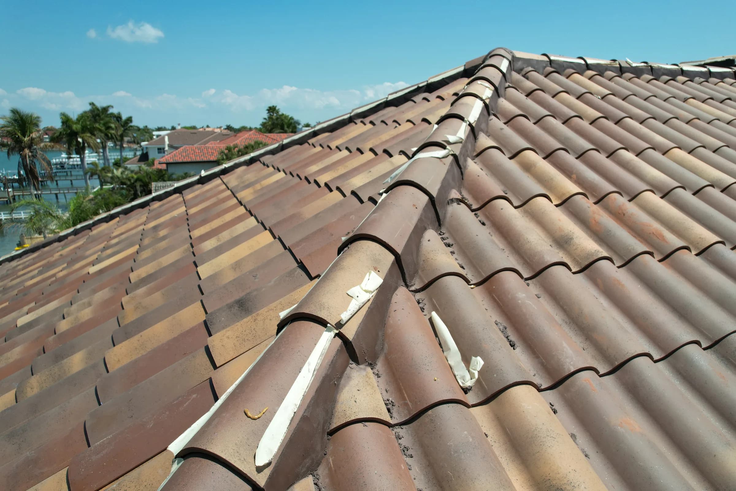 Close view of newly installed barrel tile with ridge caps running along intersecting roof lines