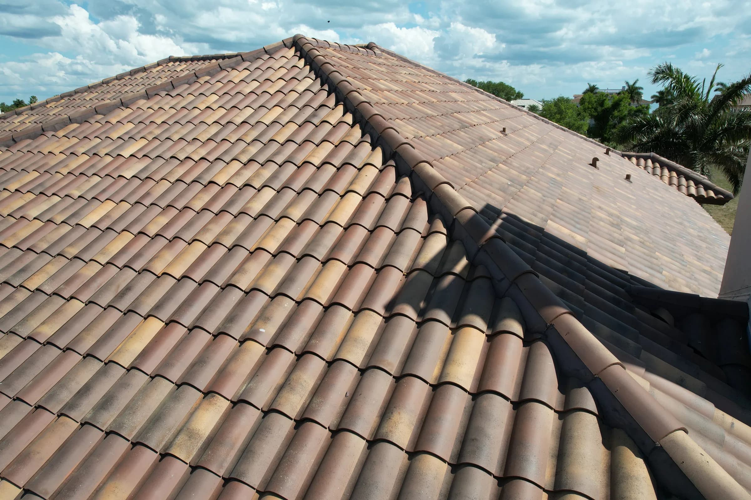 Close view across the finished Fume-blend clay tile field and mortared hip and ridge lines