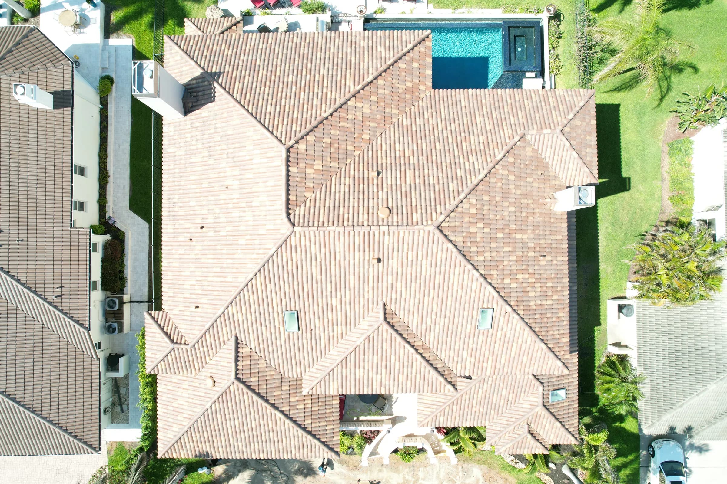Straight-down aerial view of a finished light brown barrel tile roof