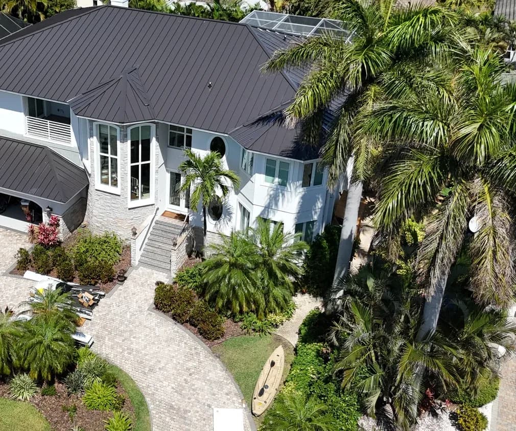 Aerial view of a finished dark standing seam metal roof on a two-story home