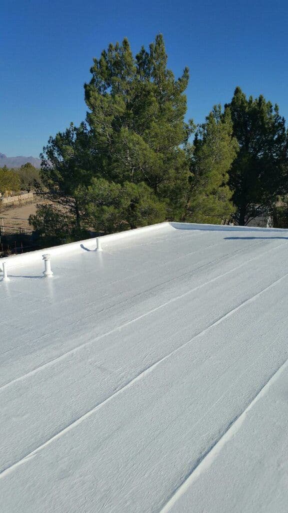 Low-slope roof under a bright white elastomeric coating with coated pipe vents