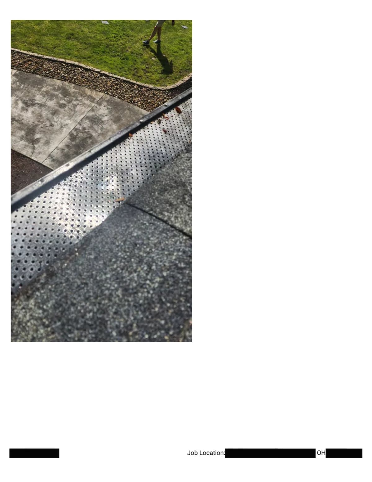 Close-up of the perforated metal gutter guard at the roof edge, photographed as part of the damage documentation.
