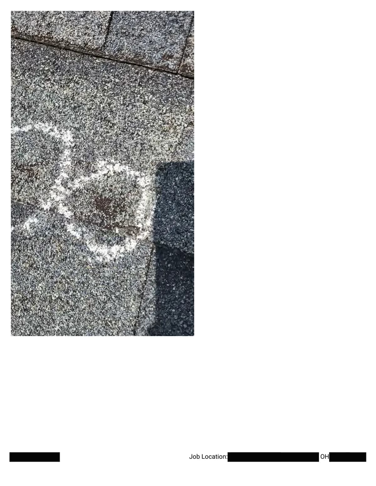 Extreme close-up of a chalk circle around a hail impact at a shingle joint, showing displaced granules.