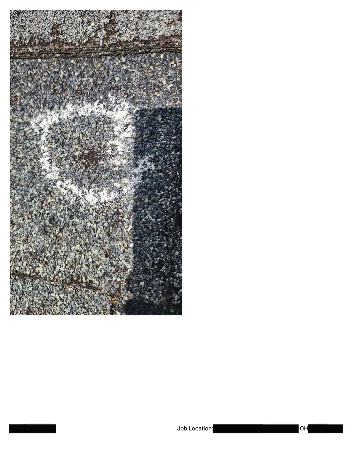 Extreme close-up of a chalk-outlined hail impact with granule loss exposing the dark asphalt beneath.