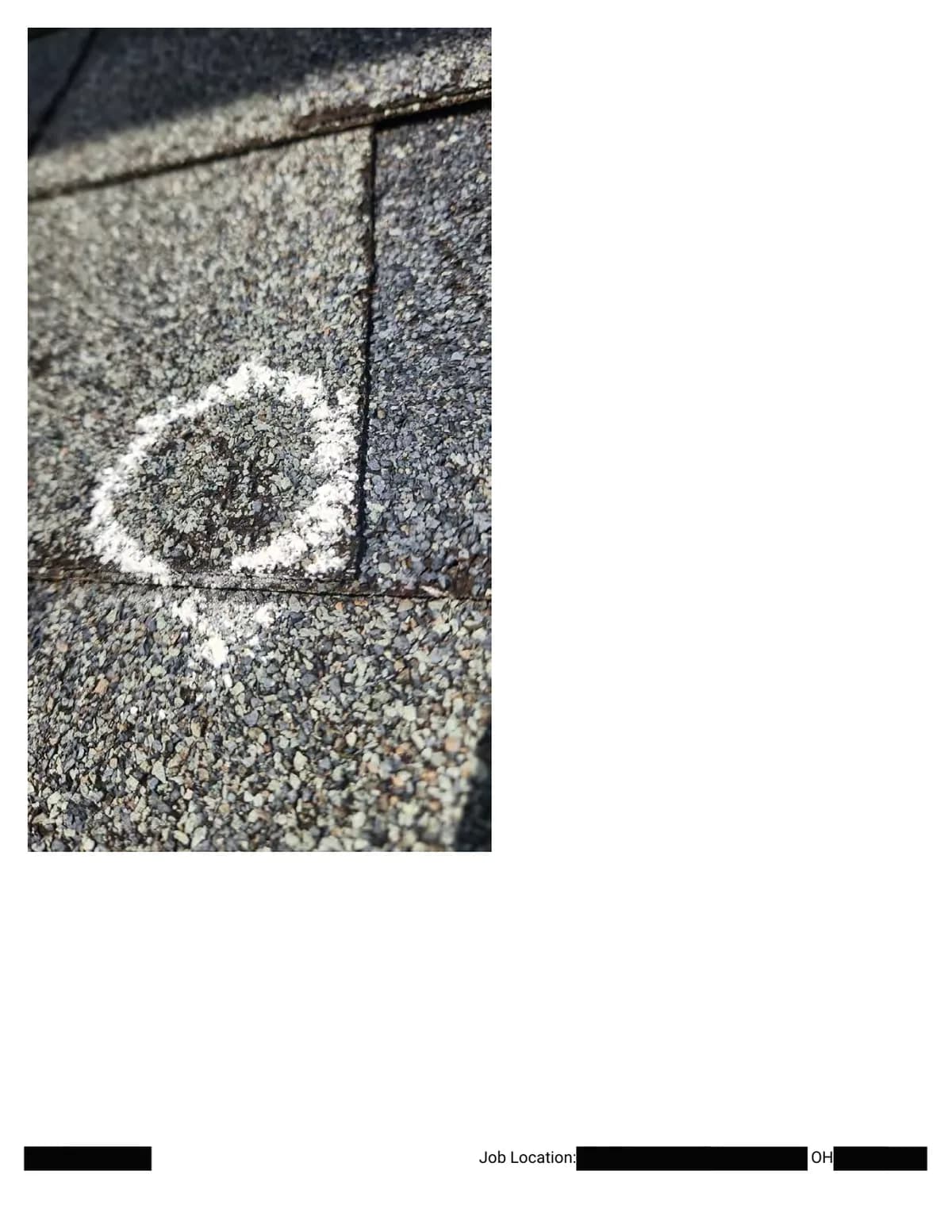 Extreme close-up of a chalk circle around a hail impact beside a shingle seam.