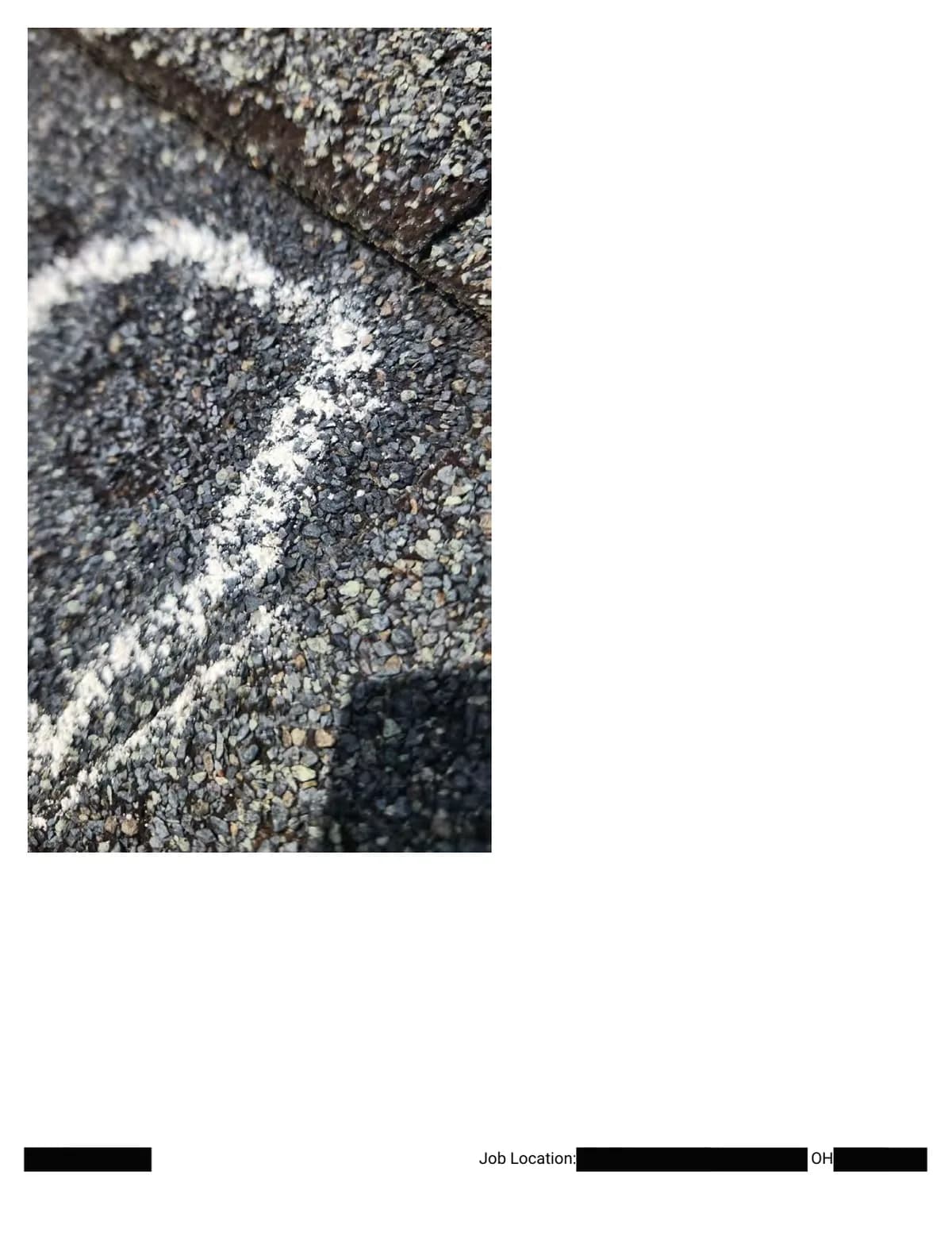 Extreme close-up of a chalk outline around a hail impact running along a shingle edge.
