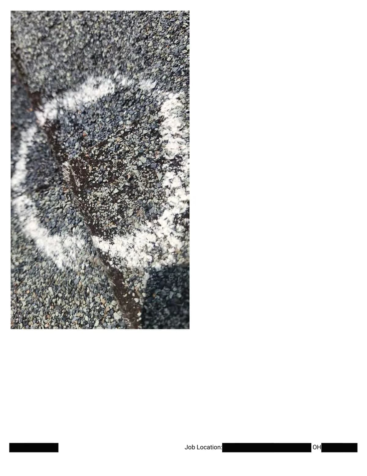 Extreme close-up inside a chalk circle: crushed granules and exposed asphalt at the point of impact.