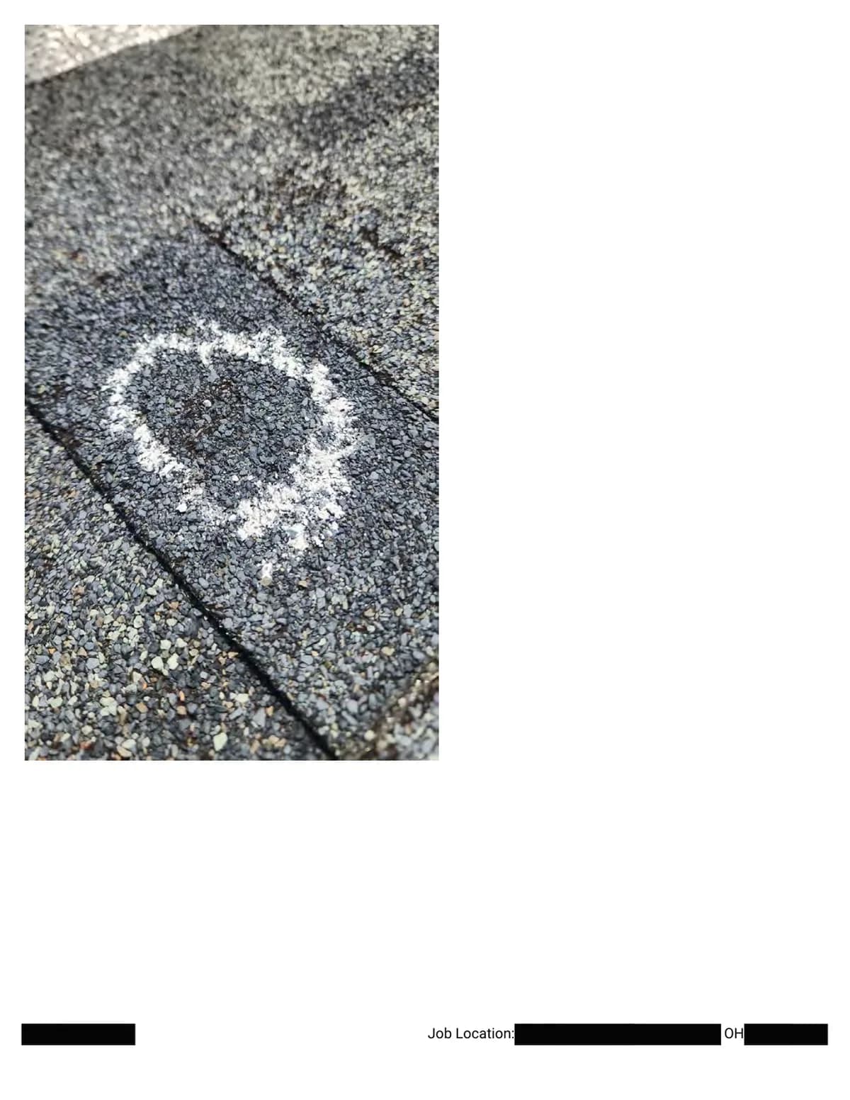 Extreme close-up of a chalk circle around a hail impact next to a shingle seam.