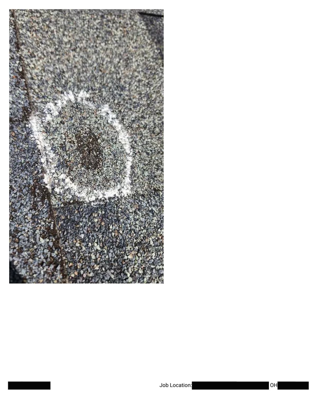Extreme close-up of a chalk circle around a hail impact with a dark bruised center.