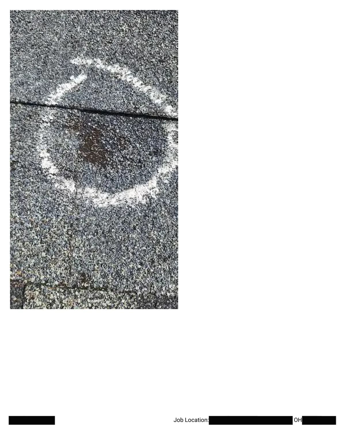 Extreme close-up of a chalk circle around a hail impact spanning a shingle joint.